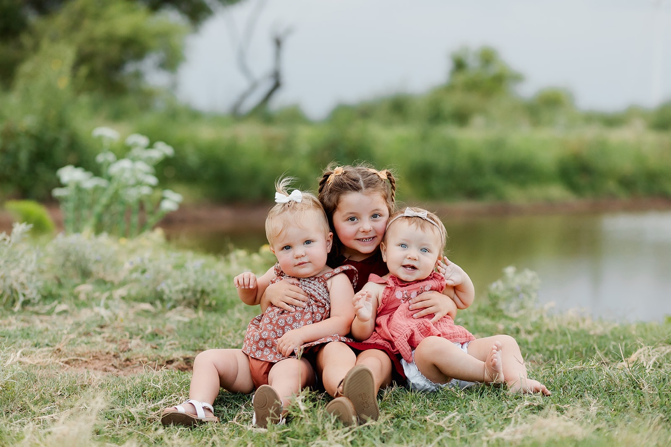 Anna's three nieces sitting together outdoors